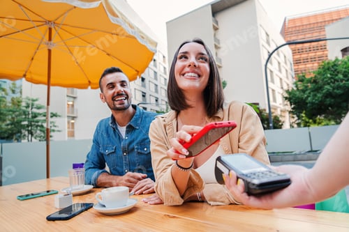 Preview: Happy couple paying the bill of the coffee shop using a cellphone contactless payment application