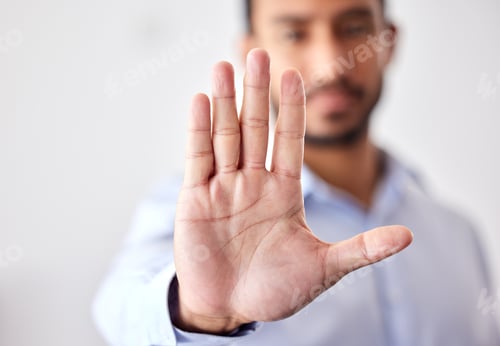 Preview: Closeup of the hand of a business man showing stop, saying no or not accepting a deal in an office