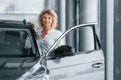 Preview: Opening the door. Woman with curly blonde hair is in autosalon