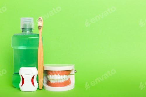Preview: Mouthwash and other oral hygiene products on colored table top view with copy space