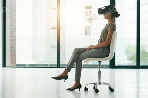 Preview: Shot of a young businesswoman wearing a VR headset in an office