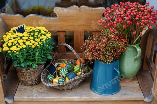 Preview: Autumn flowers and basket with pumpkins in flower shop. Halloween and Thanksgiving fall season