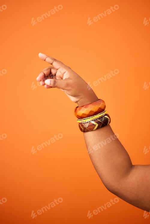 Preview: Shot of an unrecognizable person pointing against an orange background