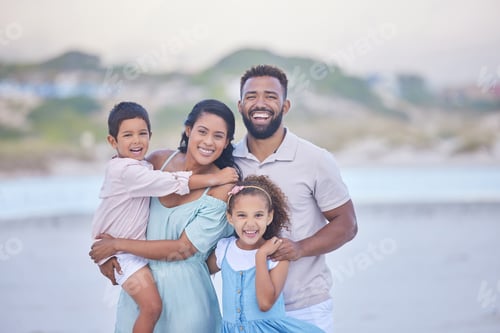 Preview: Portrait of a happy mixed race family standing together on the beach. Loving parents spending time