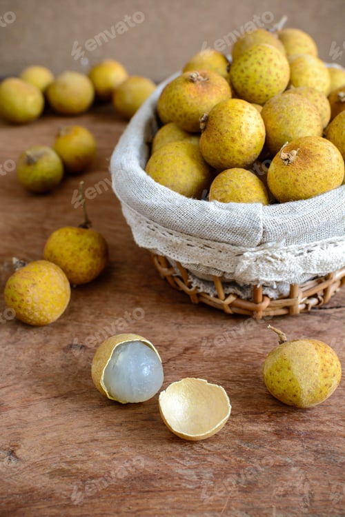 Preview: Longan (Dimocarpus longan) and peel on wooden table