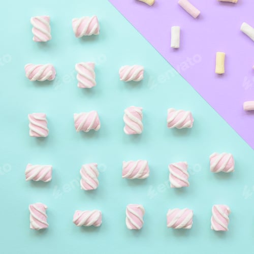 Preview: Colorful marshmallow laid out on violet and blue paper background. pastel creative