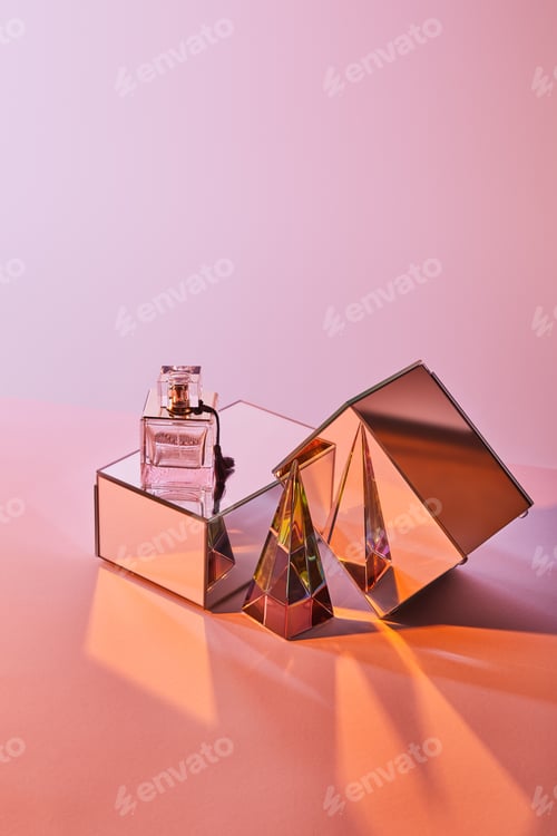 Preview: crystal transparent pyramid near perfume bottle and mirror cubes on pink background