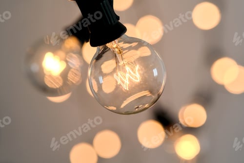 Preview: Incandescent light bulb with christmas round bokeh.