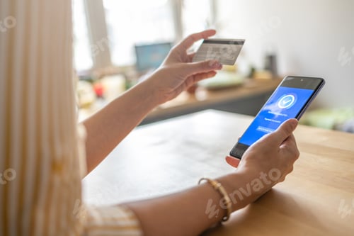 Preview: Young woman paying bills with credit card online