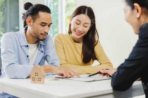 Preview: An Asian couple reads the contract before signing the purchase of a new home with a bank officer.