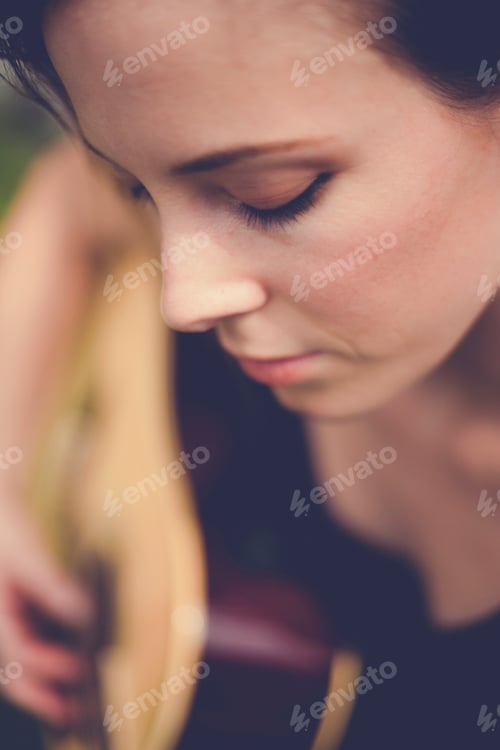 Preview: Caucasian woman is sitting and playing guitar classic