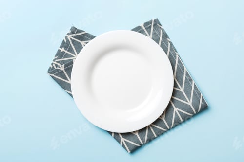 Preview: Top view on colored background empty round white plate on tablecloth for food. Empty dish on napkin