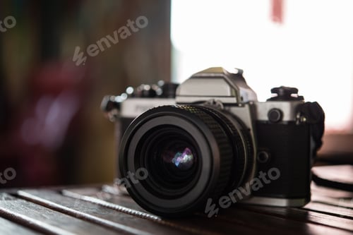 Preview: Vintage film camera on wooden table. Retro style.