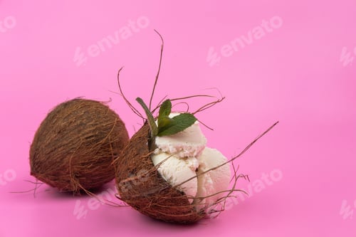 Preview: Vanilla ice cream balls in an empty coconut decorated with mint leaves on a pink background