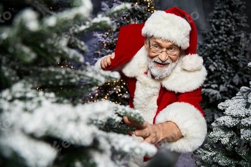 Preview: Santa Claus joyfully interacting with Christmas trees in a winter wonderland