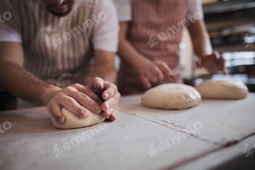 Preview: Close-up of bakers preparing fresh pastries in bakery.