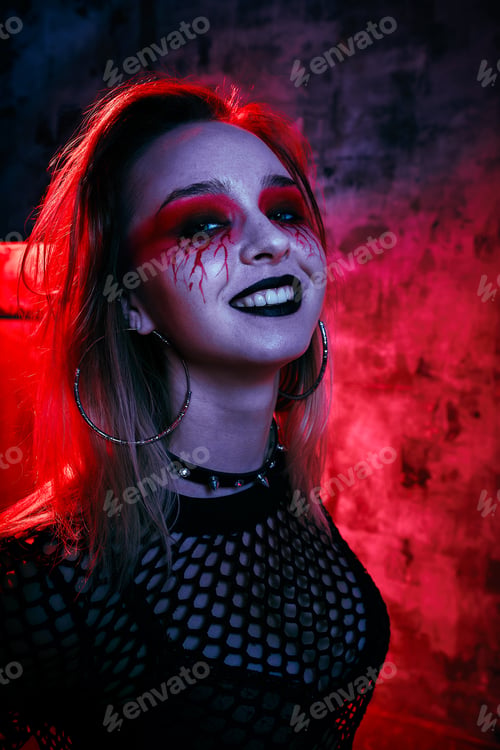 Preview: Female model in halloween outfit posing with on a red background. Gorgeous girl in clothes