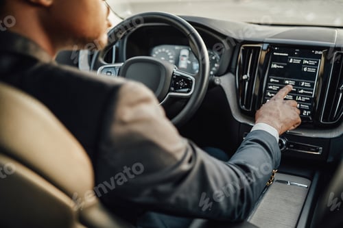 Preview: Black businessman inside car using car panel