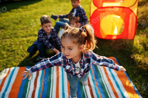 Preview: Four kids spending time together. Outdoor picnic blanket.