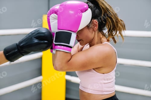 Preview: Female boxer protecting herself from her opponent's punches in the ring