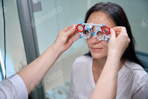 Preview: Professional oculist conducting binocular subjective refraction on female client