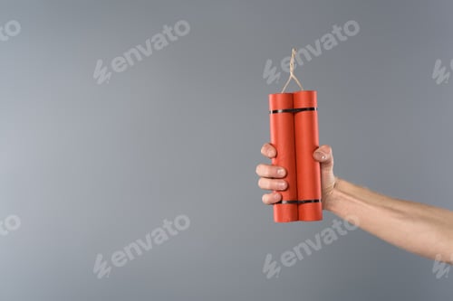 Preview: cropped view of man holding dynamite on grey background