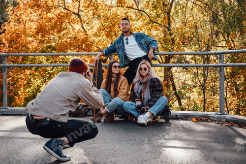 Preview: Photographer takes photo of friends in autumn park