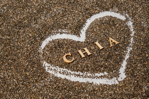 Preview: Heart made of chia seeds with word CHIA inside background. Healthy superfood rich in Omega 3 fatty