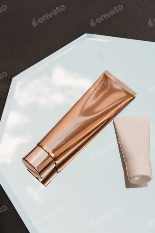 Preview: White and gold cosmetic product on mirror minimal