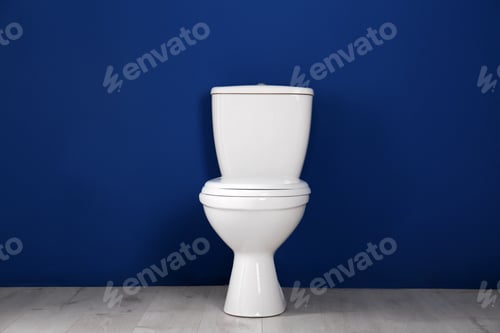 Preview: New toilet bowl near color wall indoors