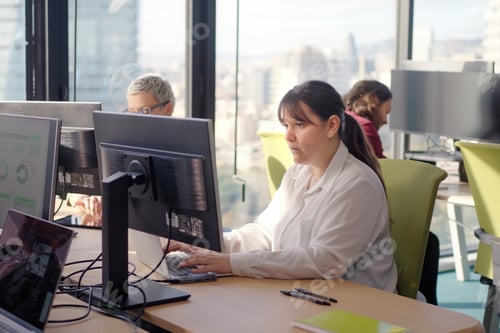 Preview: Middle aged manager working on laptop in modern office