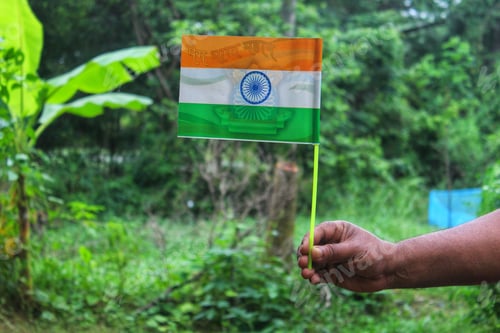Preview: Closeup of the flag of India on a small stick being held by a person