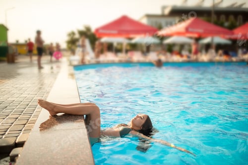 Preview: Little happy teenage girl swims in the pool
