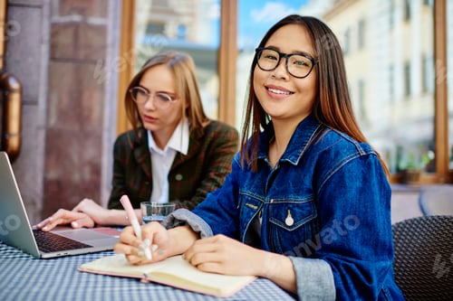Preview: Young female remote workers in street cafe
