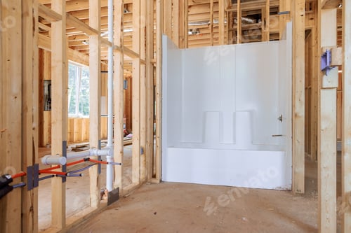 Preview: Newly added acrylic bathtub in under construction house bathroom amid beams frame