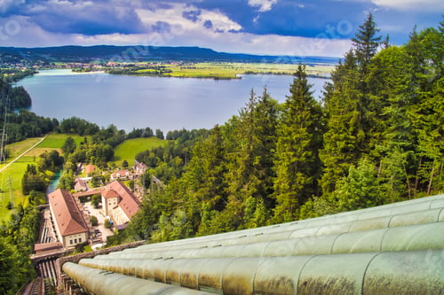Preview: High angle of pipeline hydropower next to a forest with the background of Lake Kochel, Bavaria