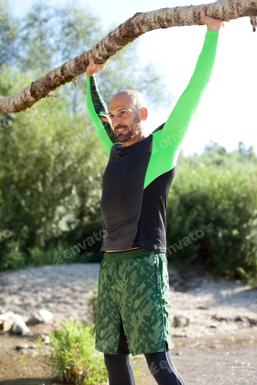 Preview: Man doing CrossFit exercise with tree trunk