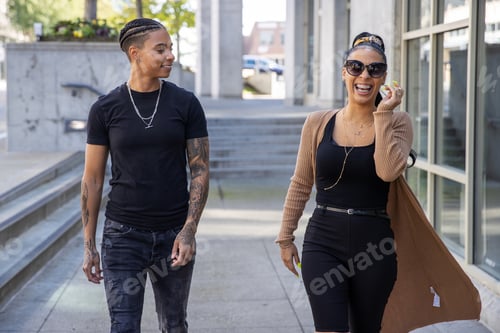 Preview: Two African American woman laughing and talking while walking together outside