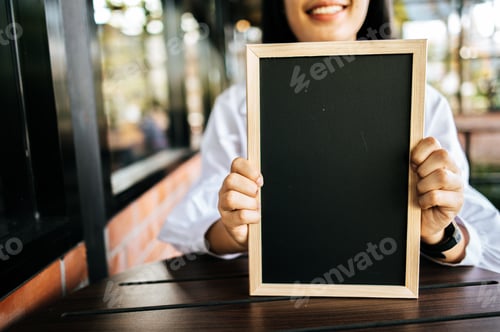 Preview: smile woman holding black board in cafe
