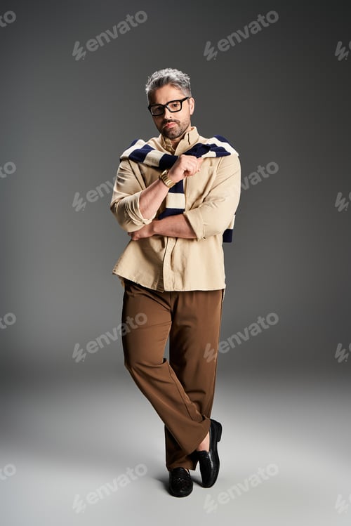 Preview: Stylish gentleman poses elegantly in a studio showcasing a modern fashion look