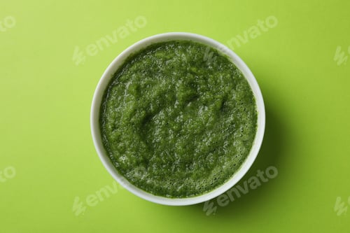 Preview: Broccoli cream soup on green background, top view