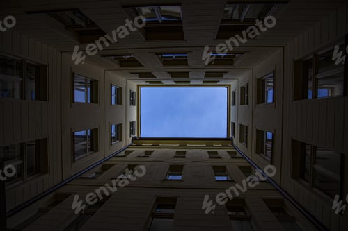 Preview: Low angle shot of the blue sky visible through the buildings captured in Prague