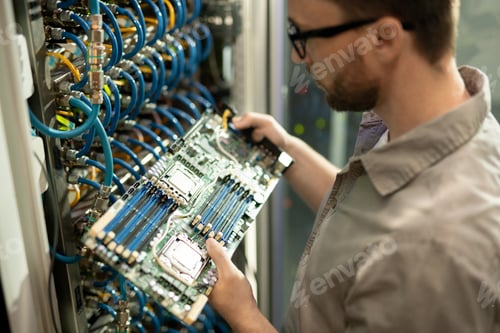 Preview: IT support specialist examining motherboard of server