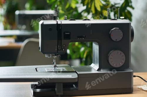Preview: Modern Sewing Machine Standing on Table in Bright Room with Green Plants