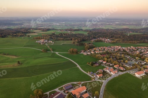 Preview: Aerial view of small town with red tiled roofs among green farm fields