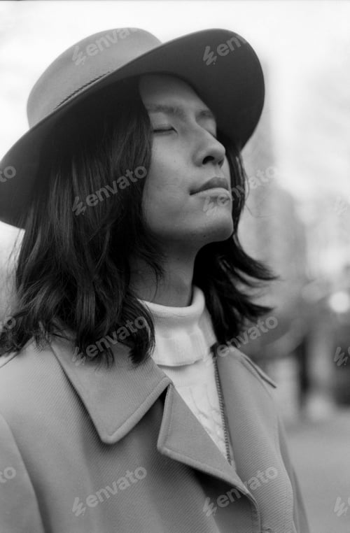 Preview: Young man wearing hat and coat enjoying fresh air in monochrome