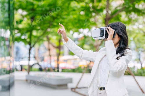 Preview: Modern business women using VR visual reality technology outdoor green park urban space