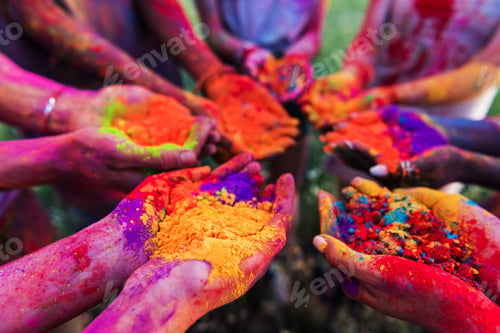 Preview: close-up partial view of young people holding colorful powder in hands at holi festival