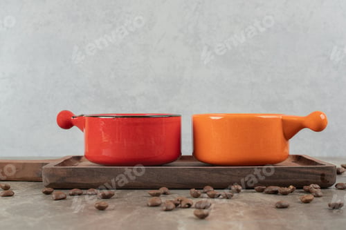 Preview: Two cups of coffee on wooden board with coffee beans