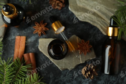 Preview: Aromatherapy concept with pine oil on black smoky table, top view